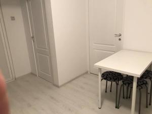 una mesa blanca y dos taburetes en una habitación en Apartament Olimp, en Olimp