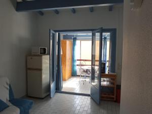 une porte ouverte menant à une cuisine avec une table dans l'établissement La Halte, à Plage dʼArgelès