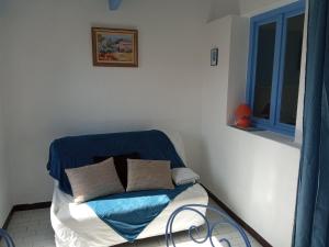 - un lit avec une couverture bleue et des oreillers dans l'établissement La Halte, à Plage dʼArgelès