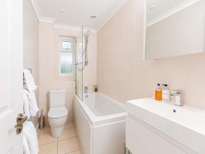 a white bathroom with a toilet and a sink at 10 Tivoli Mews - By Luxury Apartments in Cheltenham