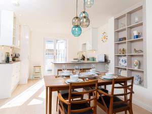 
a kitchen with a table, chairs and a refrigerator at 10 Tivoli Mews - By Luxury Apartments in Cheltenham
