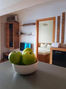 a bowl of green apples sitting on a kitchen counter at Cosy one bedroom apartment, close to Iulius Mall in Cluj-Napoca
