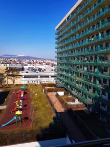 a large building with a playground in front of it at Cosy one bedroom apartment, close to Iulius Mall in Cluj-Napoca
