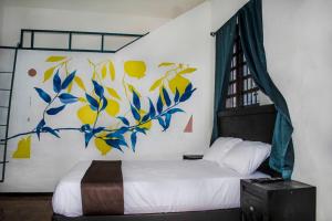 1 dormitorio con 1 cama con una pintura en la pared en Casa Lucia, en Monterrey