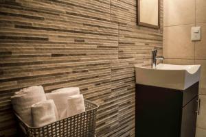 a bathroom with a sink and a basket of towels at Casa Lucia in Monterrey