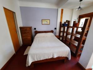 a small bedroom with a bed and wooden shelves at El Portal del Lago in Lago Puelo
