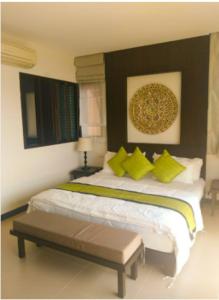 ein Schlafzimmer mit einem großen Bett mit gelben und grünen Kissen in der Unterkunft Point of view condos, tranquility bay, koh chang in Ko Chang