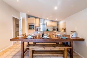 a kitchen with a large wooden island in the middle at SCHUSS D4 in Morzine +10 photos