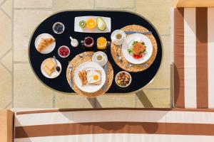 - une table avec des assiettes de petit-déjeuner dans l'établissement Palazzo Presta, à Gallipoli