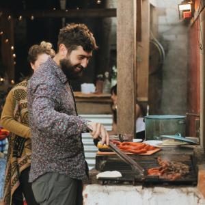 un hombre está preparando comida en una parrilla en Cabañas Campestres El Naranjo, en San Cristóbal de Las Casas