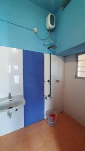 a bathroom with a sink and a blue wall at Zaina Tourist Home in Kollam
