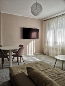 - une chambre avec un lit, une table et une télévision dans l'établissement Bryant - Pokoje & Apartamenty, à Władysławowo
