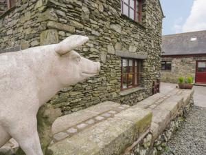 a statue of a cow standing in front of a stone building at Laithe Cottage in Ulverston