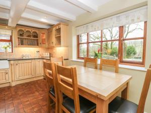 a kitchen with a wooden table and chairs at Laithe Cottage in Ulverston