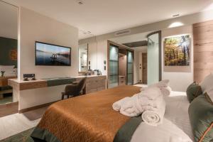 a bedroom with a large bed with towels on it at Rivage Hôtel & Spa Annecy in Annecy