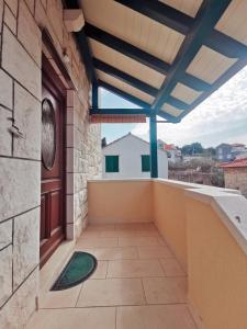 an outdoor balcony with a wooden door and a view at Villa Ela in Postira