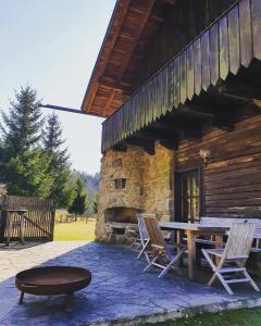 - une table de pique-nique et des chaises à l'extérieur d'une cabane en rondins dans l'établissement Naturidyll Kollnbergmühle, à Fürstenstein