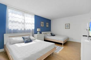 ハリウッドにある2 BEDROOMS 2 FULL BATHROOMS APT. ON THE BEACHのベッドが2つあり、青い壁の寝室