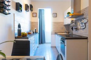 una cucina con armadi blu e lavandino di Appartamento di Daniele a Portoferraio