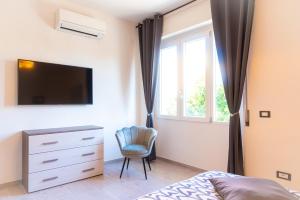 1 dormitorio con 1 cama, vestidor y TV en Appartamento di Daniele, en Portoferraio
