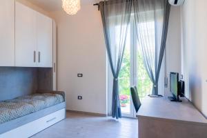 a bedroom with a bed and a tv and a window at Appartamento di Daniele in Portoferraio