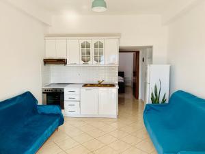 a living room with a blue couch and a kitchen at Villa Saral Mar in Sarandë