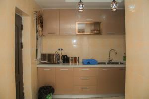 cocina con armarios marrones y fregadero en Home Away from Home in Gowon Estate, Ipaja, en Lagos