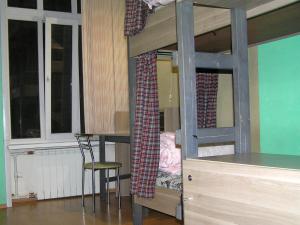 a bedroom with bunk beds with a desk and a chair at Hostel Balkonsky in Rostov on Don