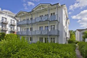 ein weißes Gebäude mit Balkonen an der Seite in der Unterkunft zentrale FeWo mit Balkon, gratis Nutzung vom AHOI Erlebnisbad und Sauna in Sellin - Villa Buskam FeWo 22 in Göhren