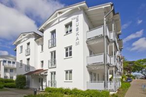 ein weißes Gebäude mit Balkonen an der Seite in der Unterkunft zentrale FeWo mit Balkon, gratis Nutzung vom AHOI Erlebnisbad und Sauna in Sellin - Villa Buskam FeWo 22 in Göhren