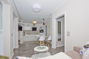 ein Wohnzimmer und eine Küche mit einer Couch und einem Tisch in der Unterkunft zentrale FeWo mit Balkon, gratis Nutzung vom AHOI Erlebnisbad und Sauna in Sellin - Villa Buskam FeWo 22 in Göhren