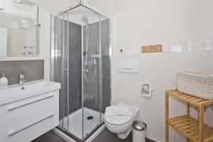 ein weißes Badezimmer mit Dusche und Toilette in der Unterkunft zentrale FeWo mit Balkon, gratis Nutzung vom AHOI Erlebnisbad und Sauna in Sellin - Villa Buskam FeWo 22 in Göhren