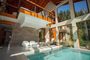 an indoor swimming pool in a house with a balcony at Origen de la Bahia in Villa La Angostura