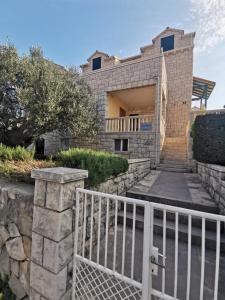 une maison avec une clôture blanche devant elle dans l'établissement Villa Ela, à Postira