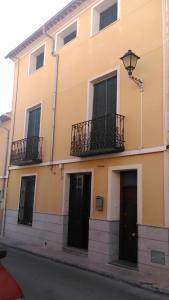 セエヒンにあるCasas de Ponienteの黒いドアとバルコニーが付いた黄色の建物