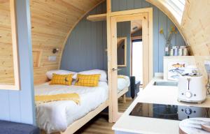 two beds in a room with an arched ceiling at Air a’ Chroit Luxury Pods in Paible
