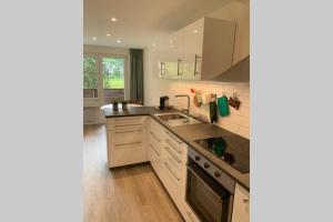 a kitchen with white cabinets and a sink at Studio neben Therme für 2 Erwachsene neu renoviert in Vals