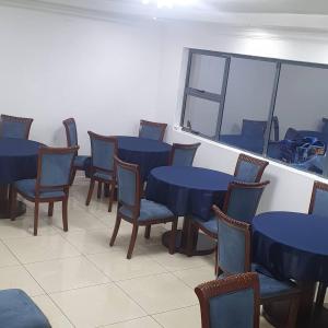 a room with blue tables and chairs and a window at Al Hamra Hotel Durban in Durban