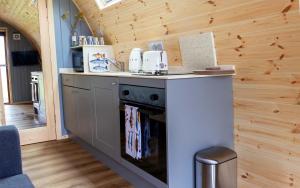 a kitchen with a stove and a counter top at Air a’ Chroit Luxury Pods in Paible