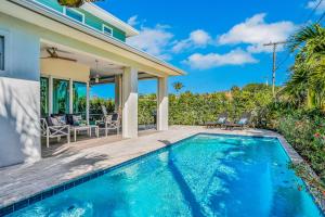 a swimming pool in front of a house at Oasis by the Sea in Cape Canaveral