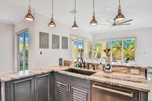 cocina con fregadero y algunas ventanas en Oasis by the Sea en Cape Canaveral