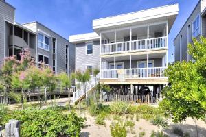 a row of apartment buildings with trees and bushes at Happy House in Ocean City
