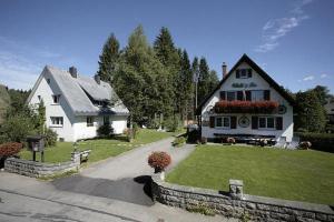 ein großes weißes Haus mit einem Hof und einem Haus in der Unterkunft Gästehaus Wald und See in Titisee-Neustadt