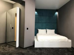 1 dormitorio con cama blanca y espejo en SPA Hotel, en Vorzel