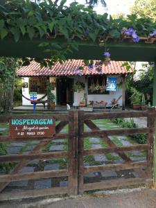 una pequeña casa detrás de una valla de madera con una puerta en Saquarema hospedagem en Saquarema
