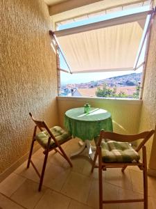 a table and two chairs in a room with a window at Villa Ela in Postira