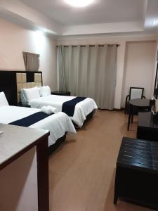 a hotel room with two beds and a table at Al Hamra Hotel Durban in Durban