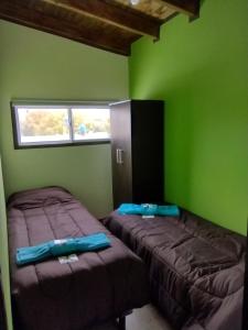 twee bedden in een kamer met groene muren bij MALARGUE STYLE,A 100 Mtrs DEL CENTRO,MUY UBICADO in Malargüe