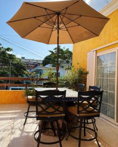 una mesa y sillas con una sombrilla en el patio en Departamentos K&B en Playa del Carmen
