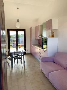 サンタンナ・アッレージにあるOrchidea Porto Pinoの紫色のソファとテーブル付きのリビングルーム